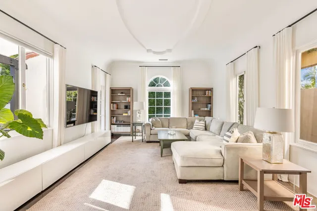 a living room with furniture and large windows