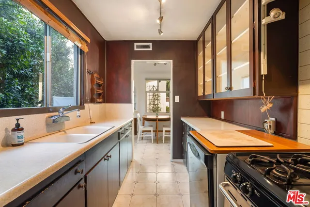 a kitchen with a sink a stove and cabinets