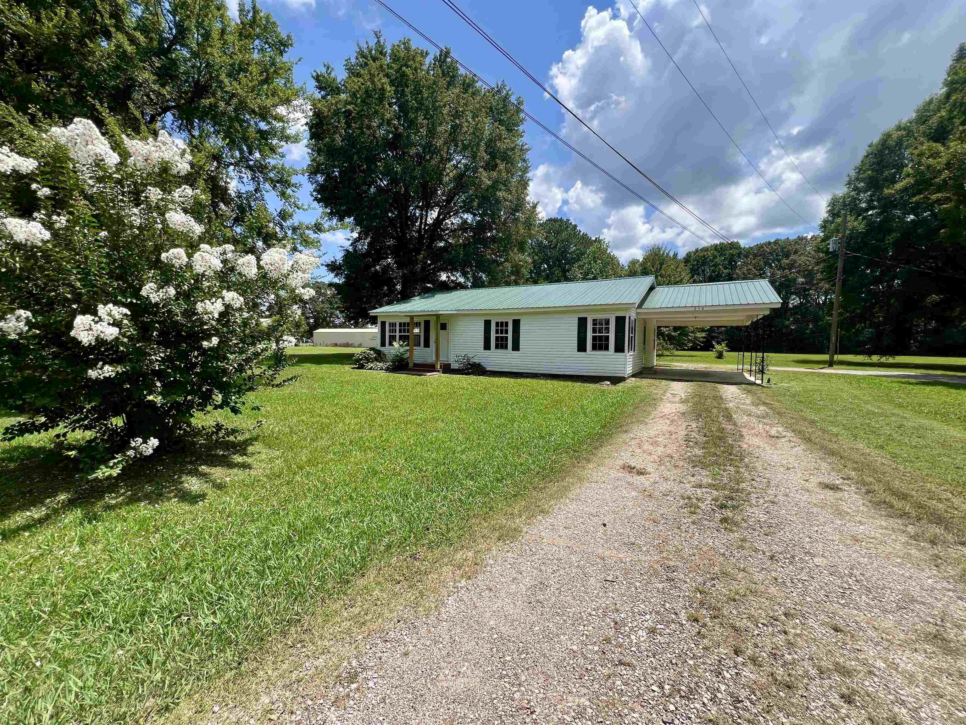 a view of a house with a big yard and potted plants