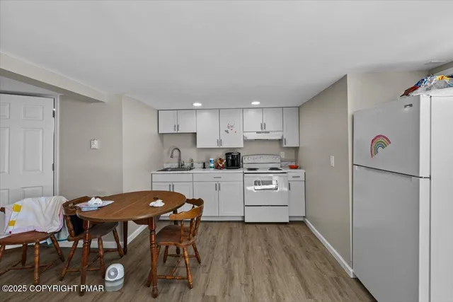 a living room with furniture a flat screen tv and kitchen view
