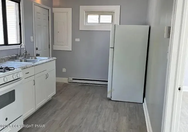 a view of an empty room with wooden floor and closet