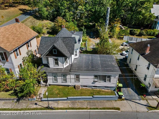 an aerial view of a house with swimming pool and lawn chairs under an umbrella