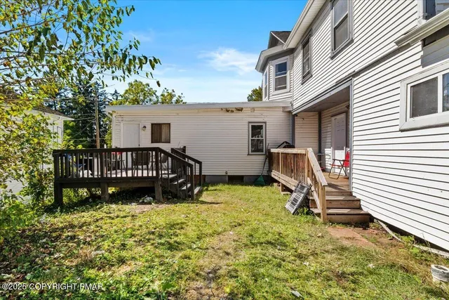 a view of a chair and tables in the back yard of the house