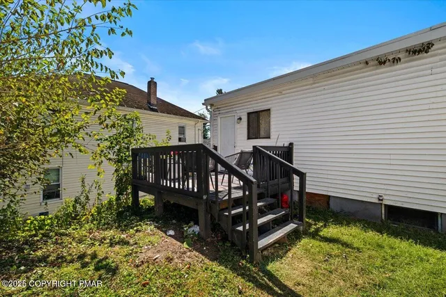a view of a house with wooden deck and furniture