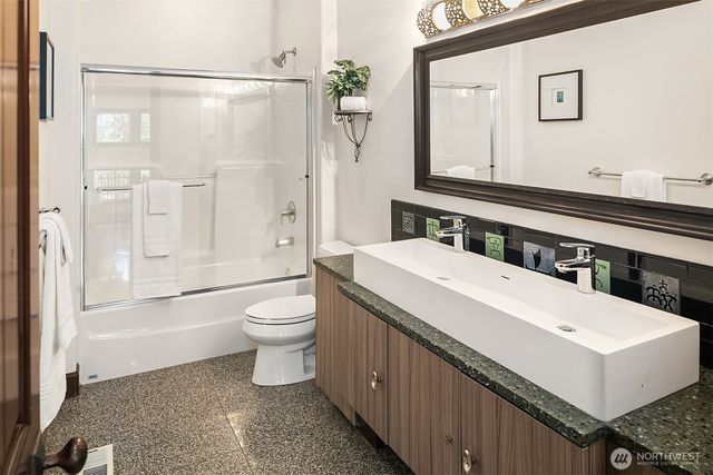 a bathroom with a double vanity sink toilet mirror and shower