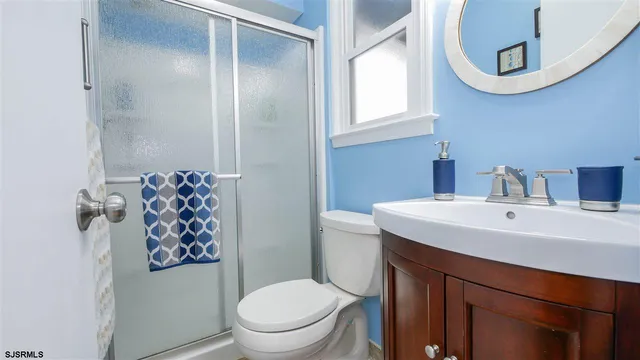 a bathroom with a toilet sink vanity and mirror