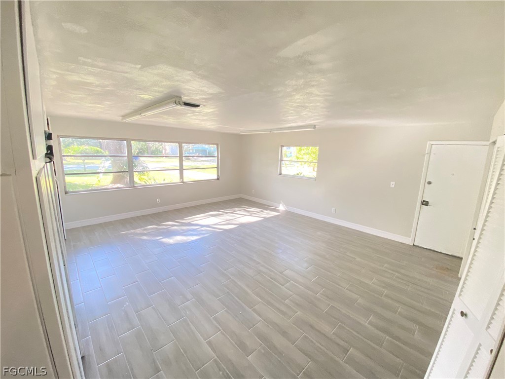 17890 Leetana Road North Fort Myers, FL 33917 - Photo 11 of 25 an empty room with wooden floor and windows