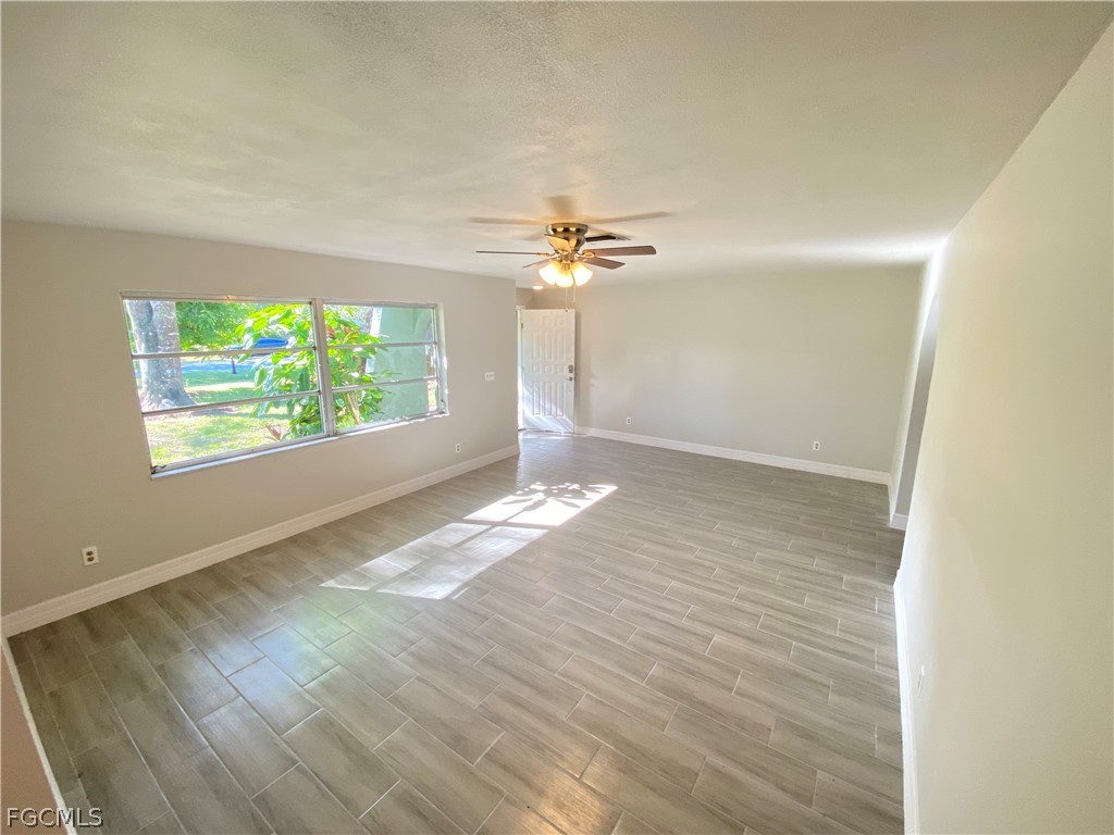 17890 Leetana Road North Fort Myers, FL 33917 - Photo 19 of 25 an empty room with wooden floor fan and window