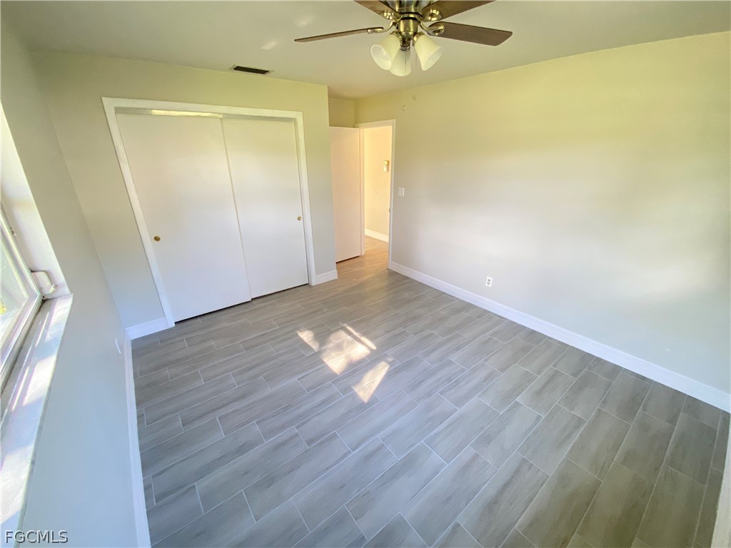17890 Leetana Road North Fort Myers, FL 33917 - Photo 21 of 25 an empty room with wooden floor fan and windows
