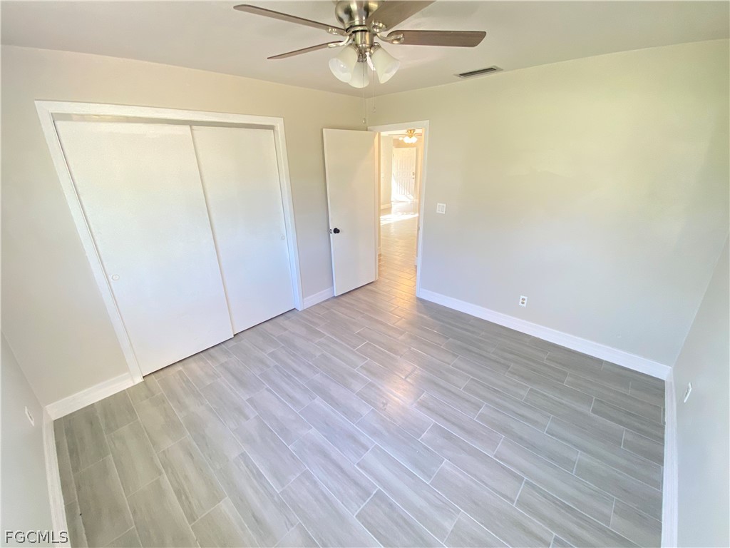 17890 Leetana Road North Fort Myers, FL 33917 - Photo 23 of 25 an empty room with wooden floor and fan