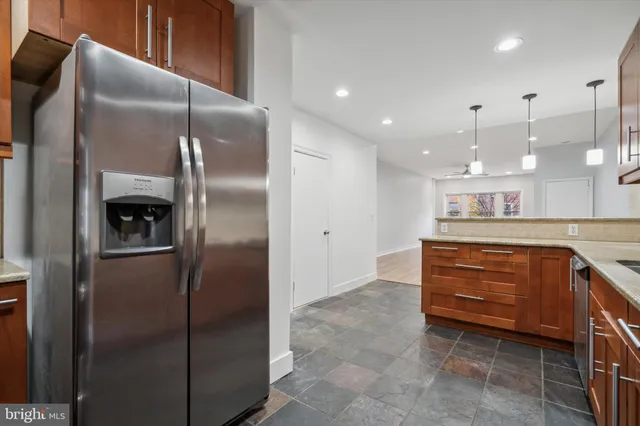 a kitchen with kitchen island a counter top space cabinets and stainless steel appliances