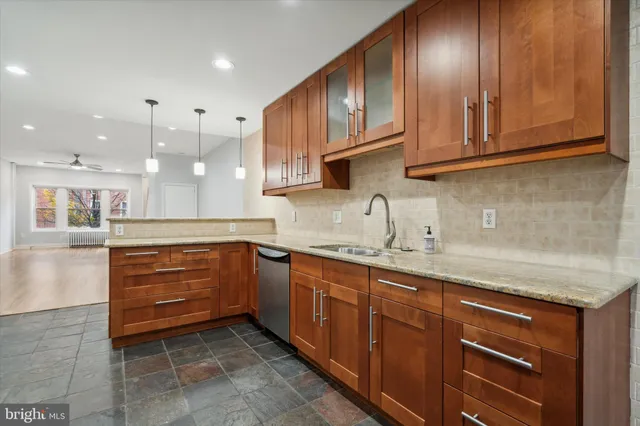 a kitchen with granite countertop stainless steel appliances wooden cabinets and a sink