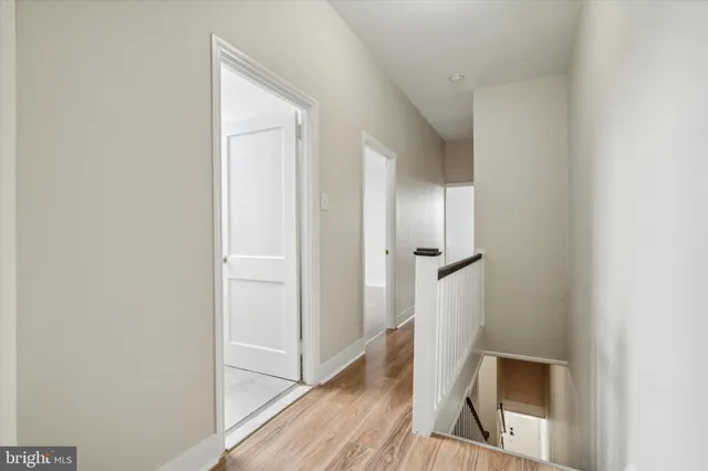 a view of a hallway with wooden floor and staircase