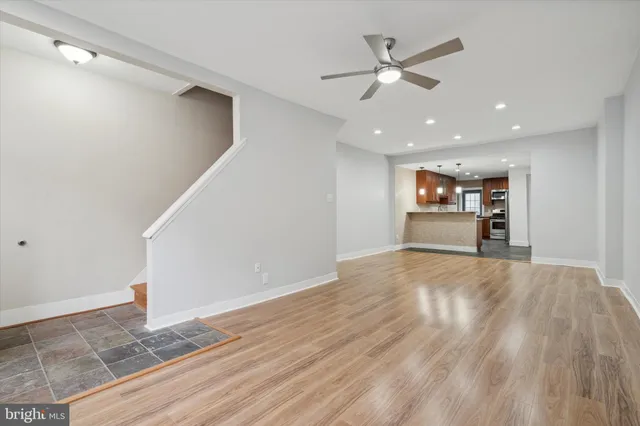 a view of empty room with wooden floor and ceiling fan