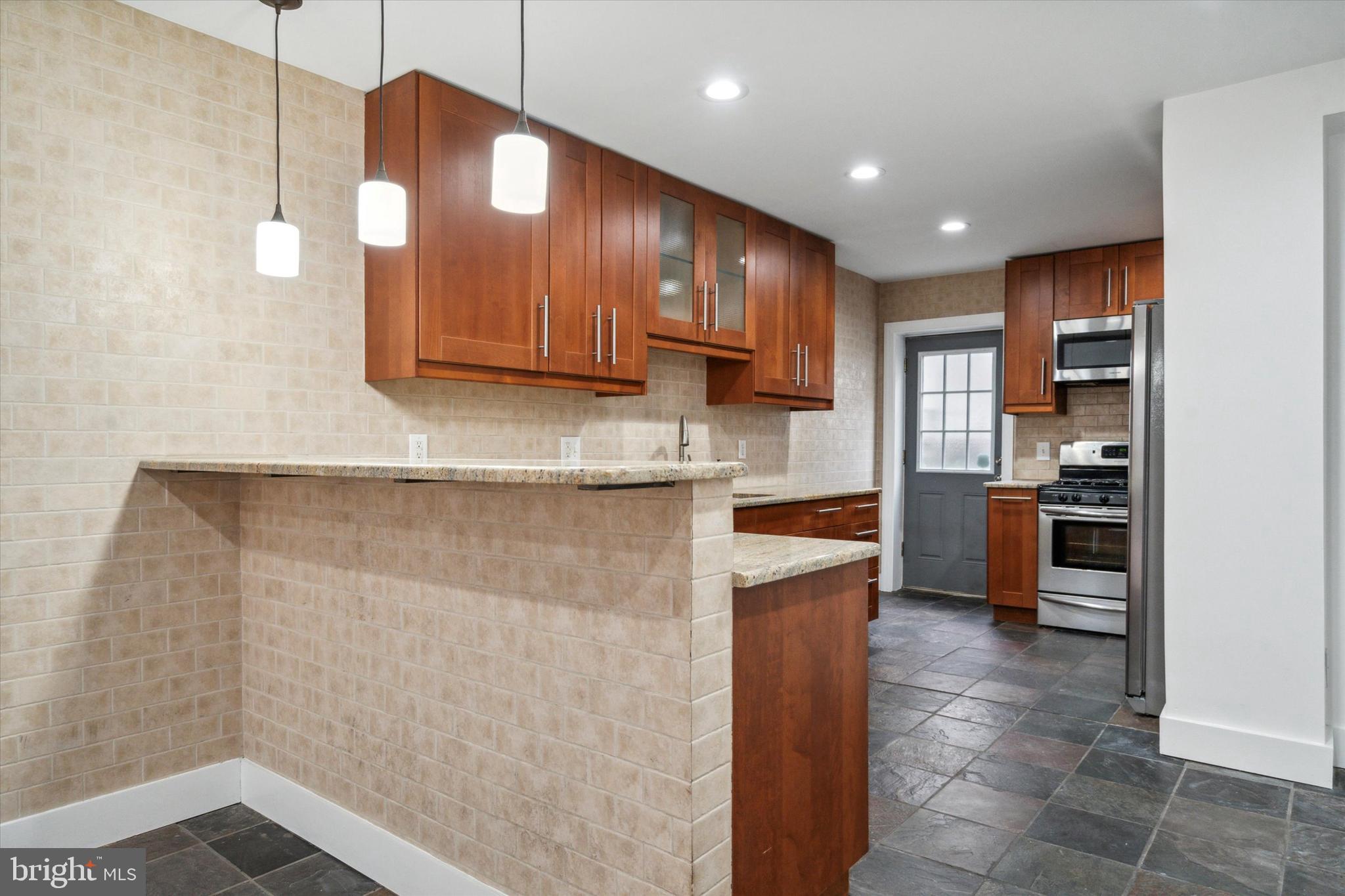 711 Reed Street Philadelphia, PA 19147 - Photo 10 of 32 a kitchen with stainless steel appliances granite countertop a refrigerator a stove and a sink