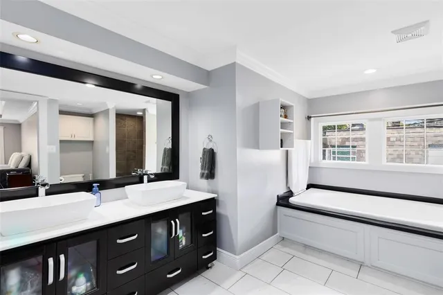 a bathroom with double vanity and a bathtub