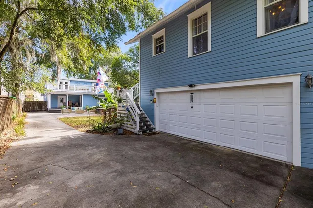 a view of a house with a small yard and large tree
