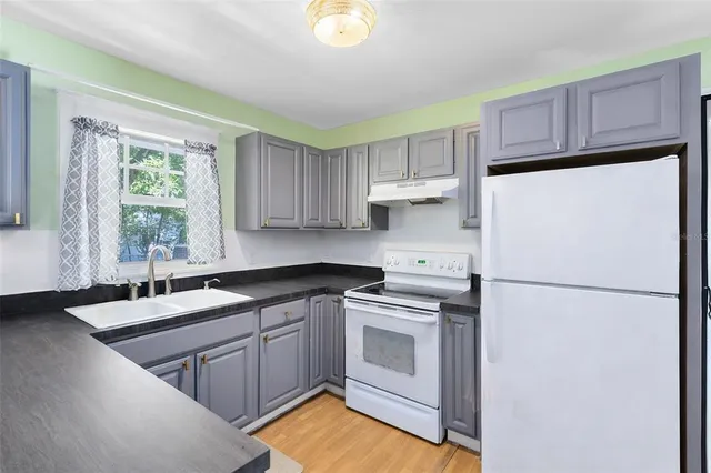 a kitchen with a sink a refrigerator and window