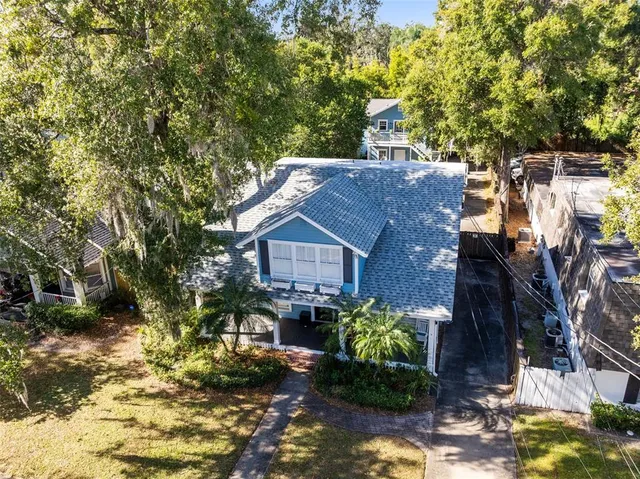 a view of a house with a yard and large tree