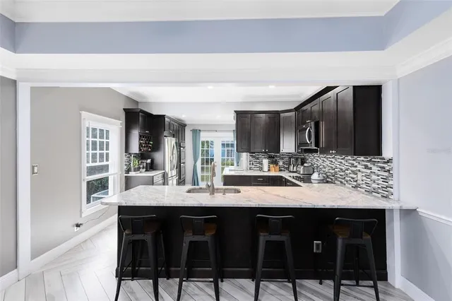 a kitchen with granite countertop a sink and chairs