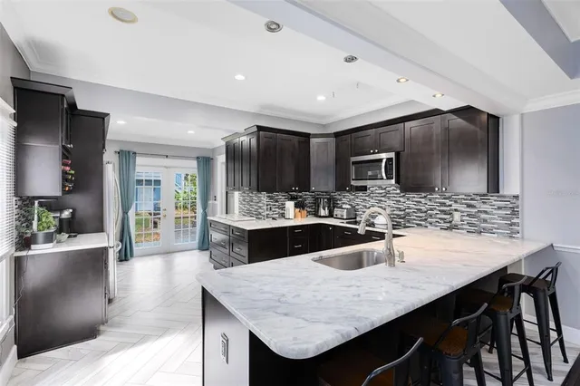 a kitchen with granite countertop kitchen island stainless steel appliances a sink and counter space