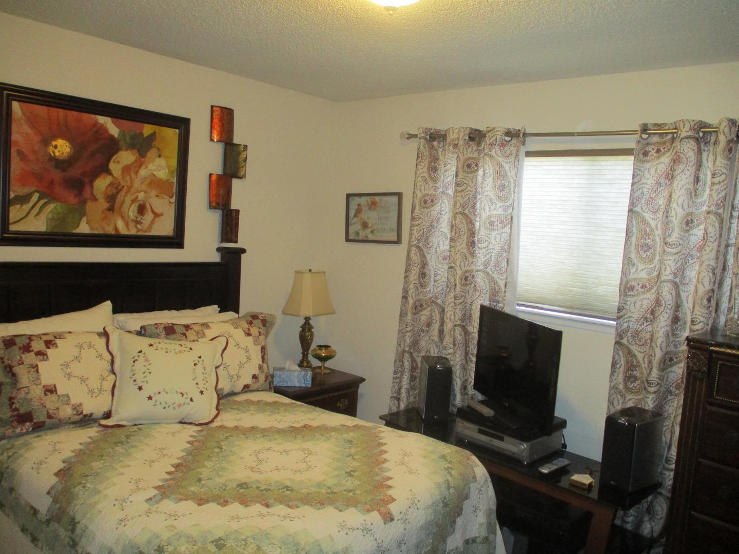 467 Tuttle Avenue Watsonville, CA 95076 - Photo 6 of 7 a bedroom with a bed and a tv