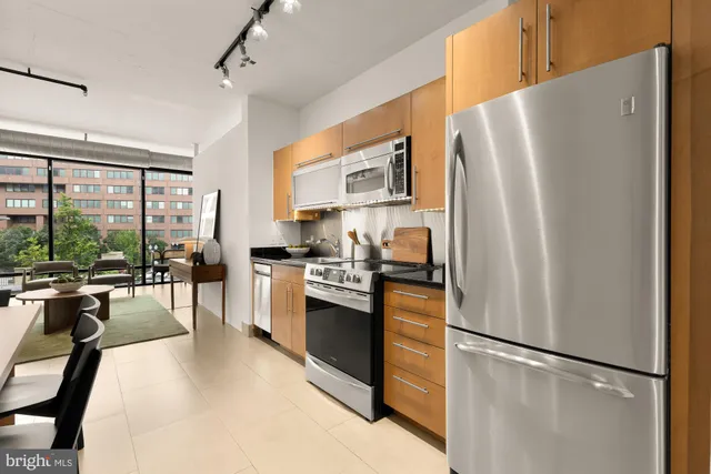 a kitchen with stainless steel appliances granite countertop a refrigerator and a stove