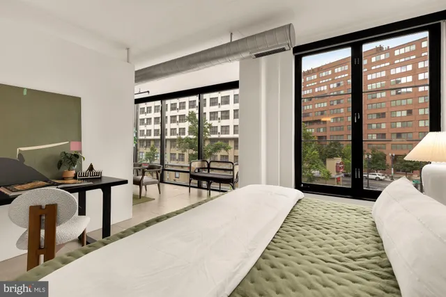 a bedroom with furniture and large windows