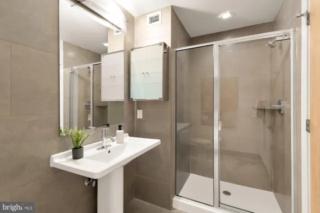 a bathroom with a shower sink and mirror