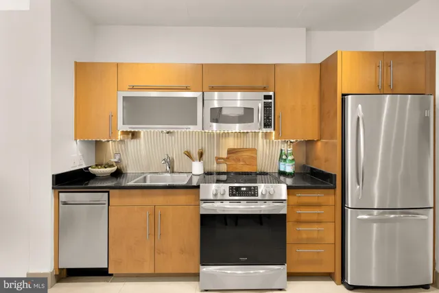 a kitchen with stainless steel appliances a refrigerator sink and stove