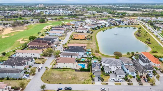 an aerial view of residential houses with outdoor space and lake view