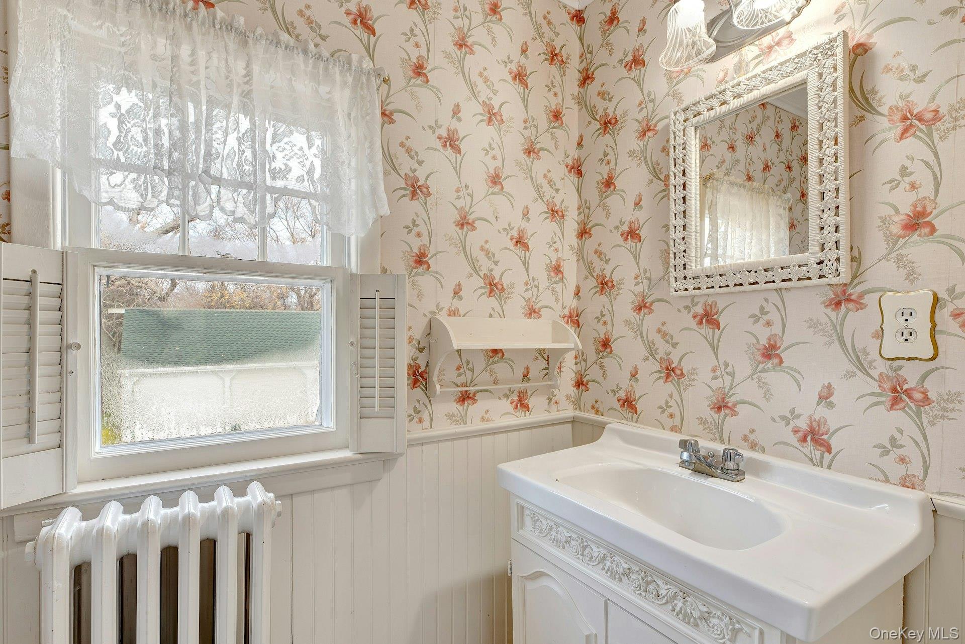 1760 Albertson Lane Greenport, NY 11944 - Photo 18 of 40 Bathroom with wainscoting, wallpapered walls, radiator, and vanity