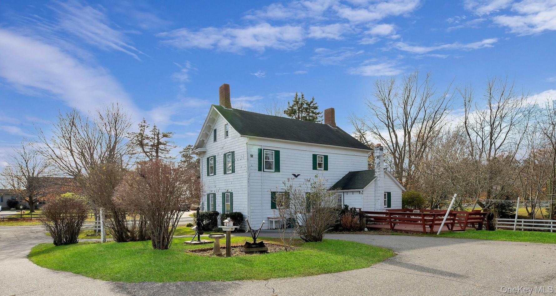 1760 Albertson Lane Greenport, NY 11944 - Photo 21 of 40 View of home's exterior featuring a chimney, driveway, and a deck