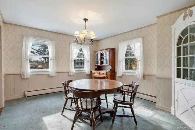 a dining room with furniture a chandelier and wooden floor