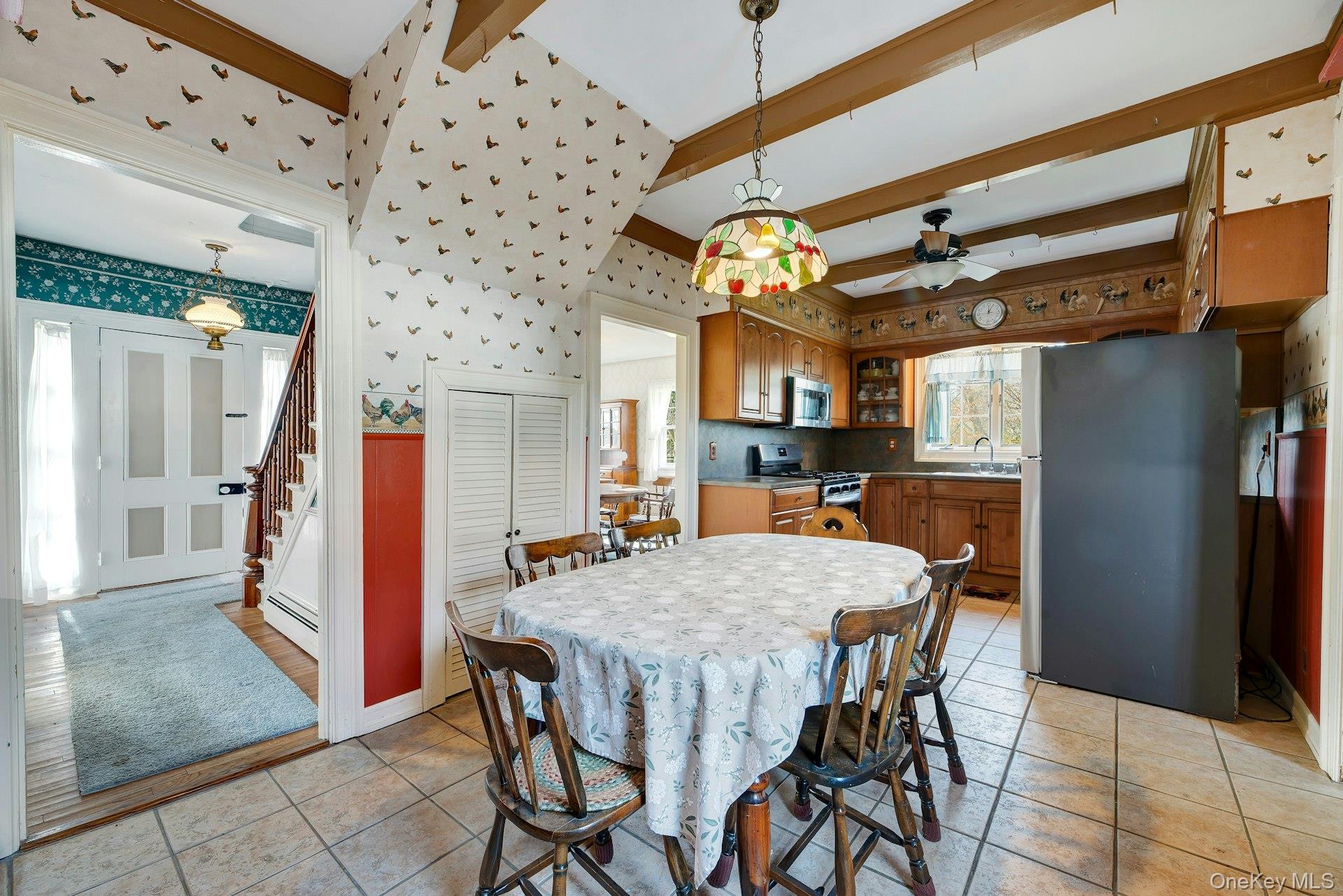 1760 Albertson Lane Greenport, NY 11944 - Photo 9 of 40 Dining room featuring wallpapered walls, a baseboard radiator, stairs, ceiling fan, and beam ceiling