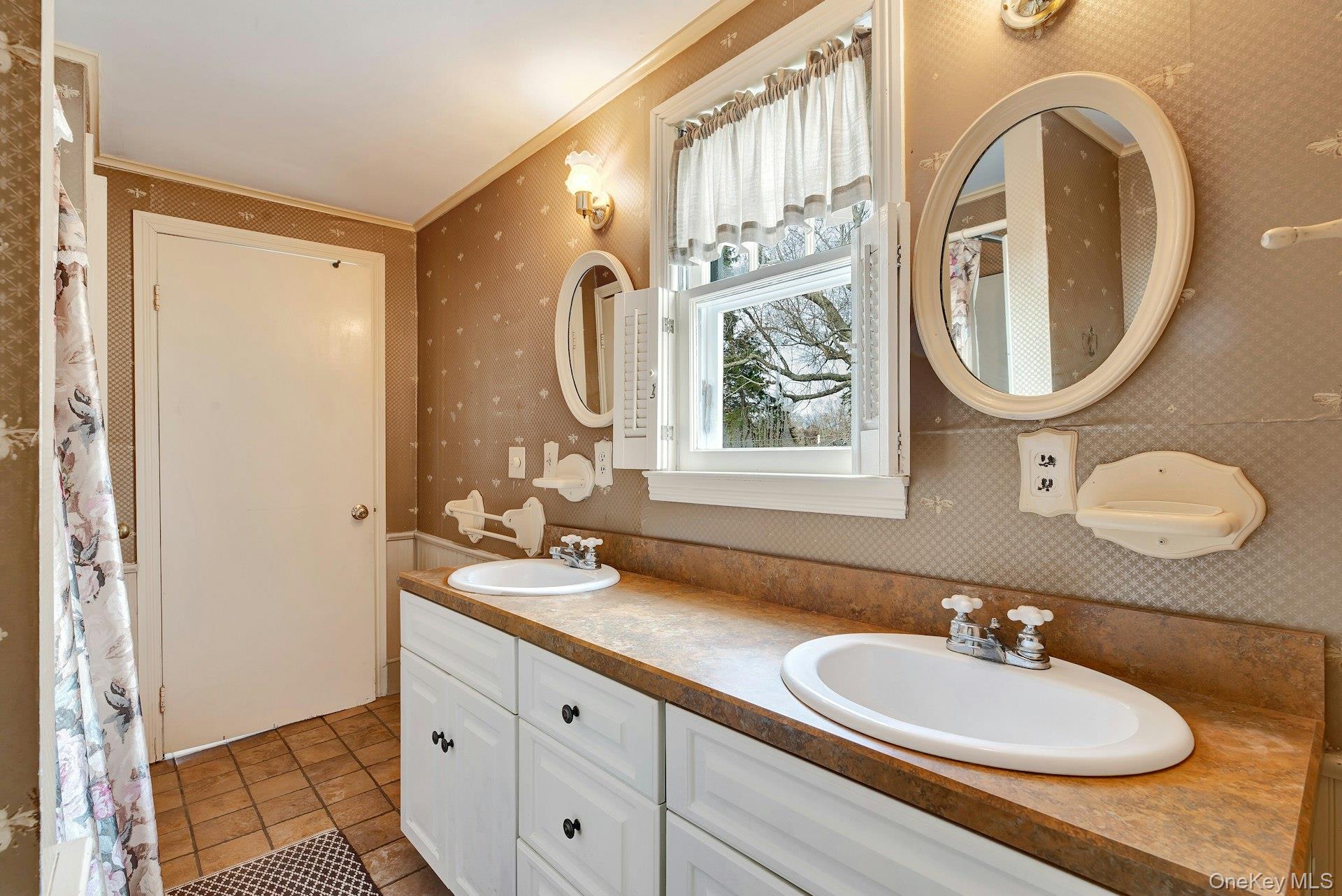 1760 Albertson Lane Greenport, NY 11944 - Photo 10 of 40 Bathroom with wallpapered walls, double vanity, light tile patterned floors, curtained shower, and ornamental molding