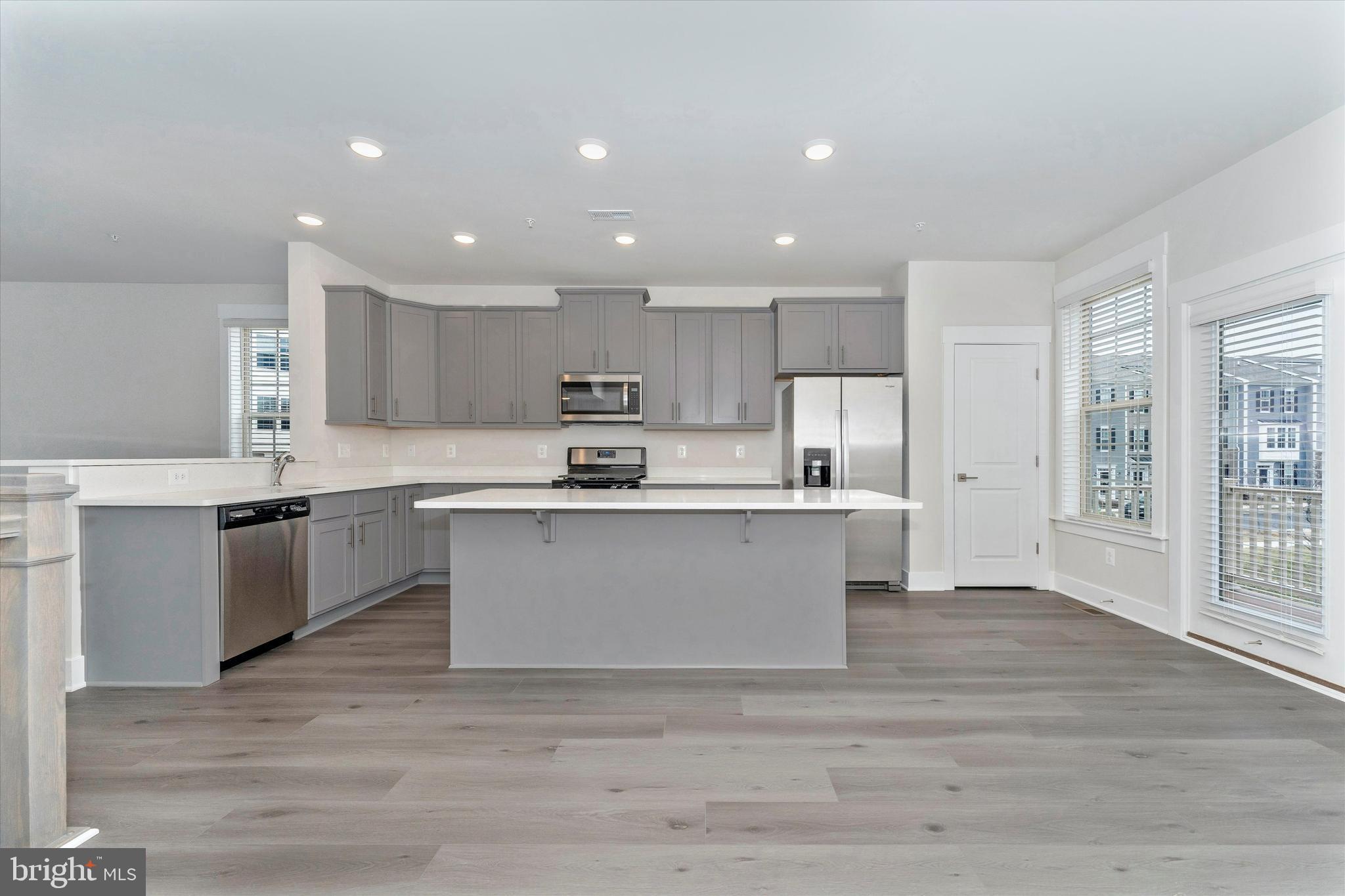 2923 Osprey Way Frederick, MD 21701 - Photo 13 of 42 a view of kitchen with granite countertop refrigerator oven sink and white cabinets with wooden floor