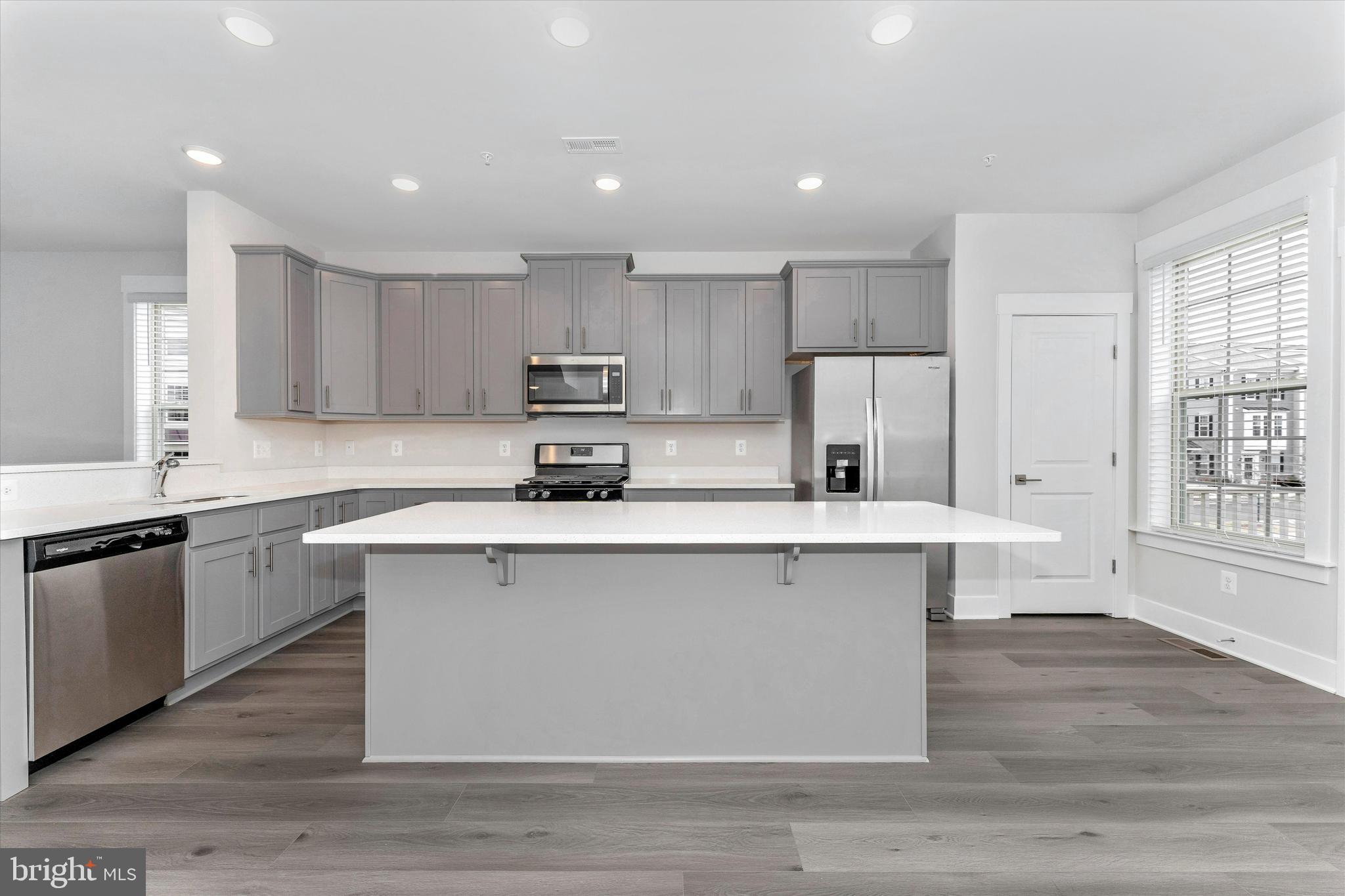 2923 Osprey Way Frederick, MD 21701 - Photo 18 of 42 a kitchen with kitchen island white cabinets and stainless steel appliances