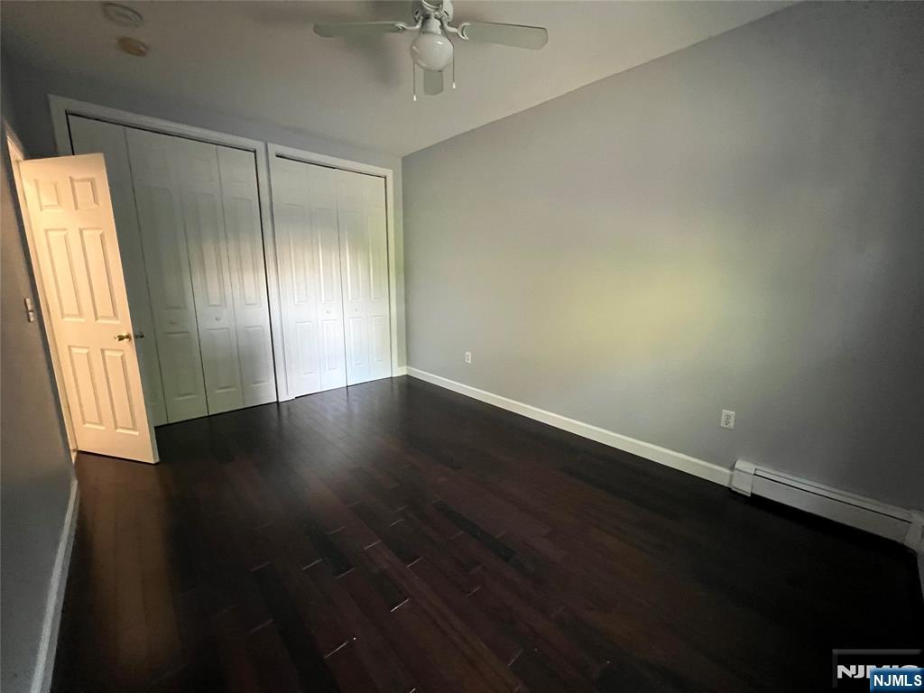 68 Liberty Street, Unit 1 Lodi, NJ 07644 - Photo 12 of 23 an empty room with wooden floor and windows with curtains