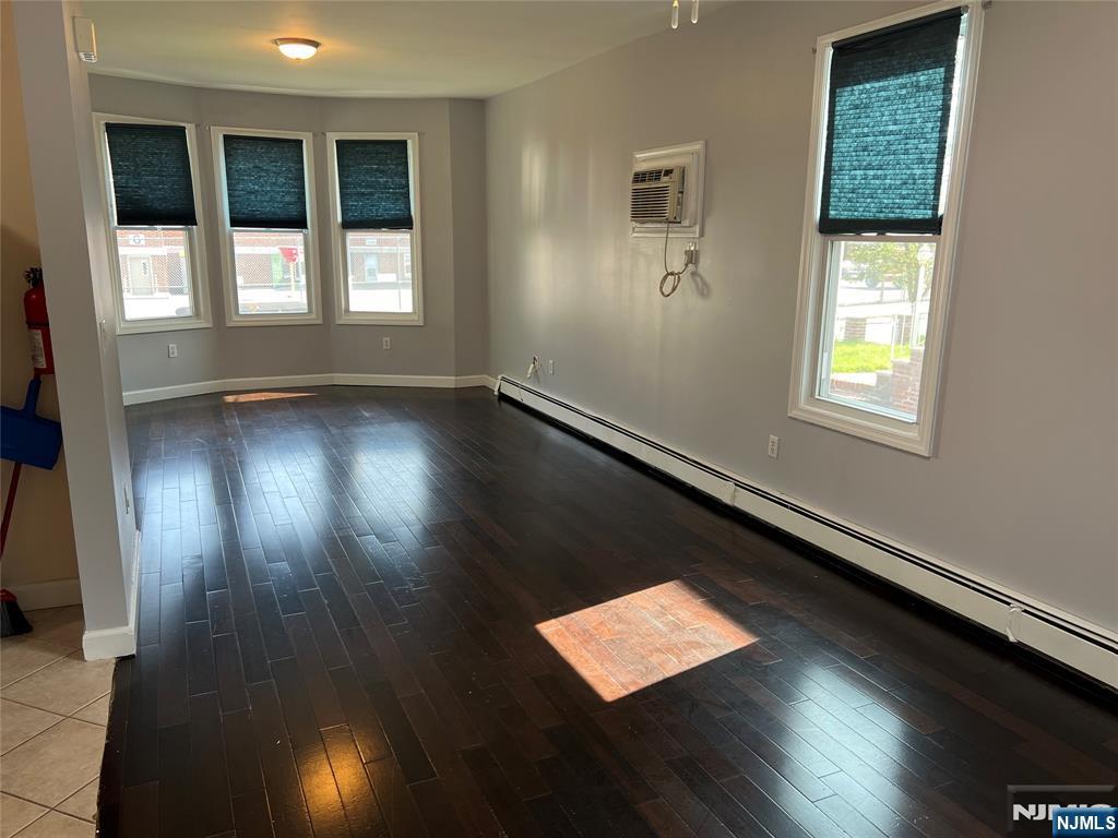 68 Liberty Street, Unit 1 Lodi, NJ 07644 - Photo 2 of 23 an empty room with wooden floor and windows
