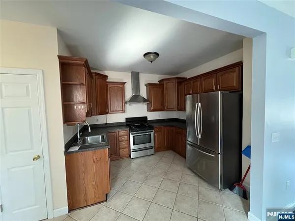 a kitchen with granite countertop a refrigerator and a stove top oven