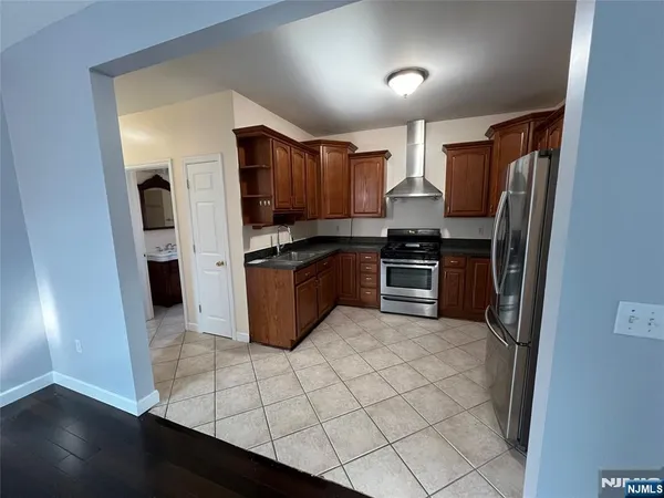 a kitchen with stainless steel appliances a refrigerator and a stove top oven