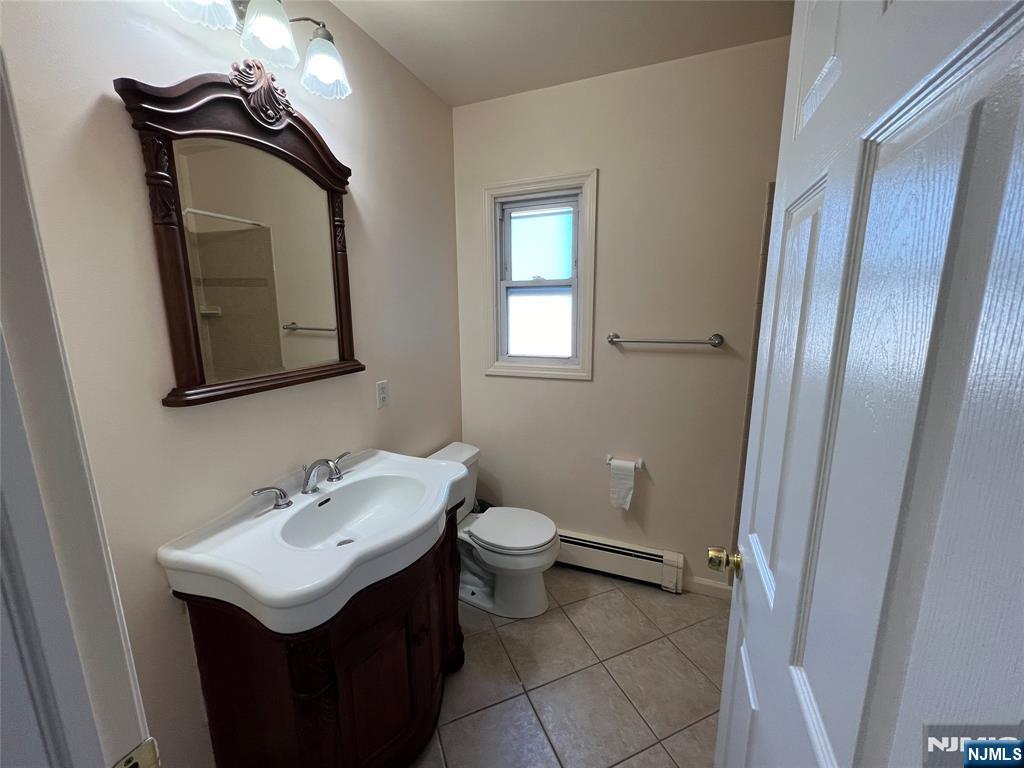 68 Liberty Street, Unit 1 Lodi, NJ 07644 - Photo 8 of 23 a bathroom with a toilet sink and mirror