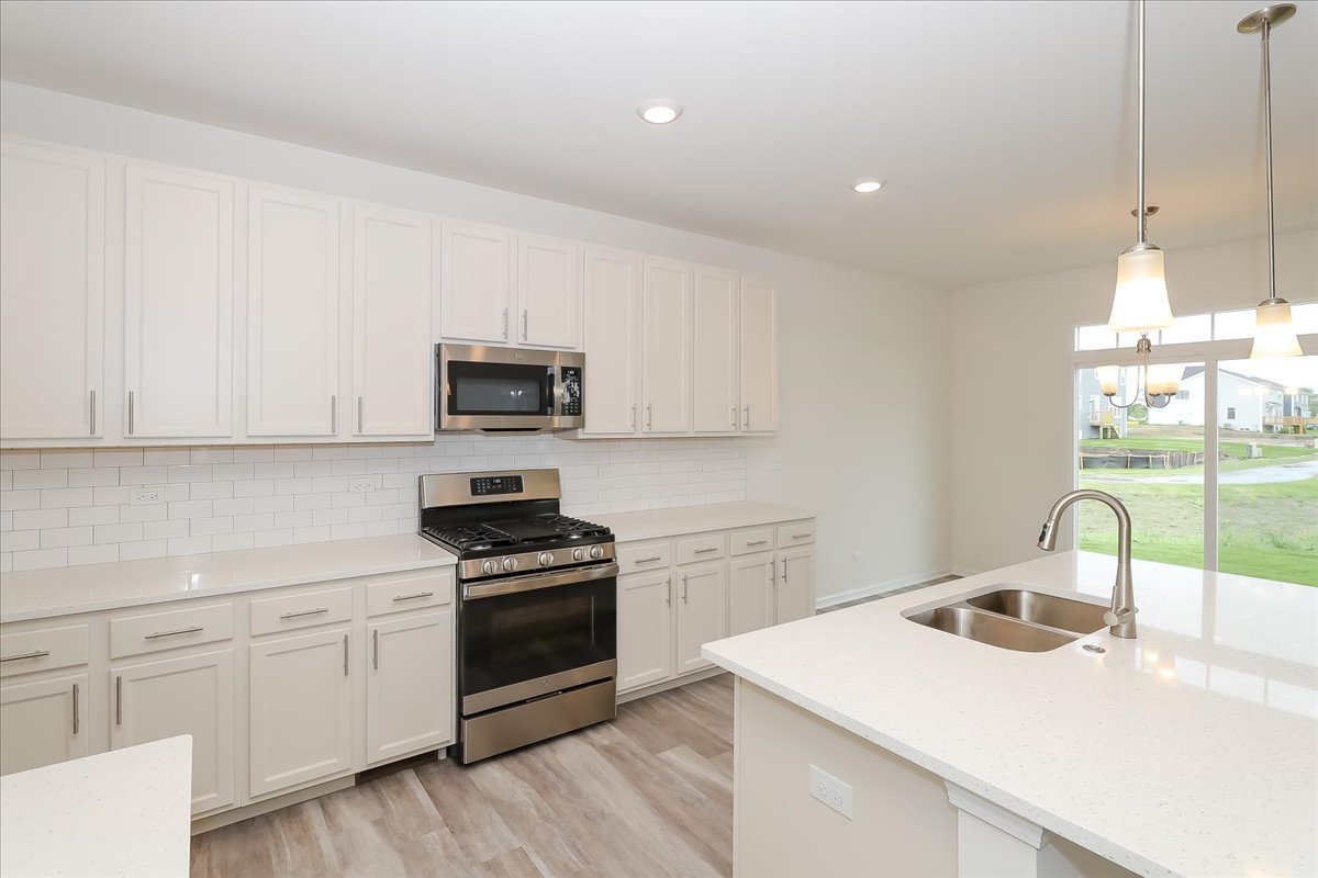 860 Preston Lane Oswego, IL 60543 - Photo 14 of 34 a kitchen with a sink a stove and microwave