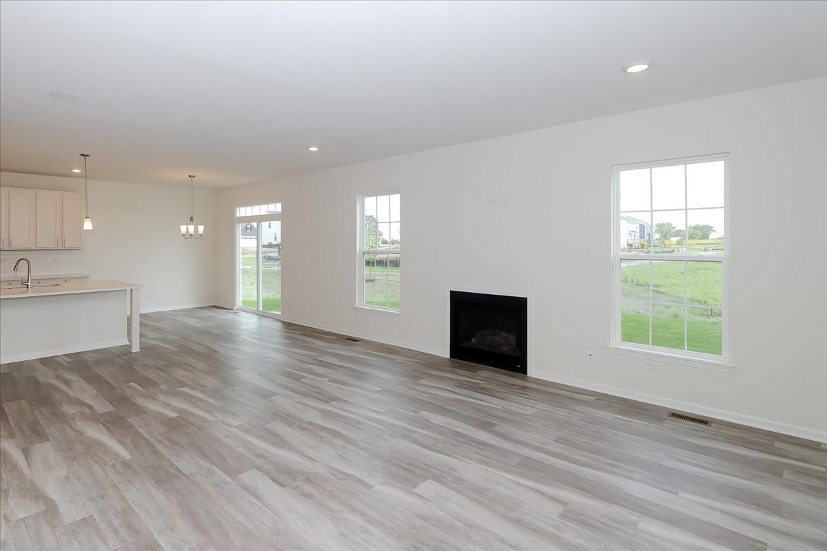 860 Preston Lane Oswego, IL 60543 - Photo 10 of 34 an empty room with wooden floor and windows