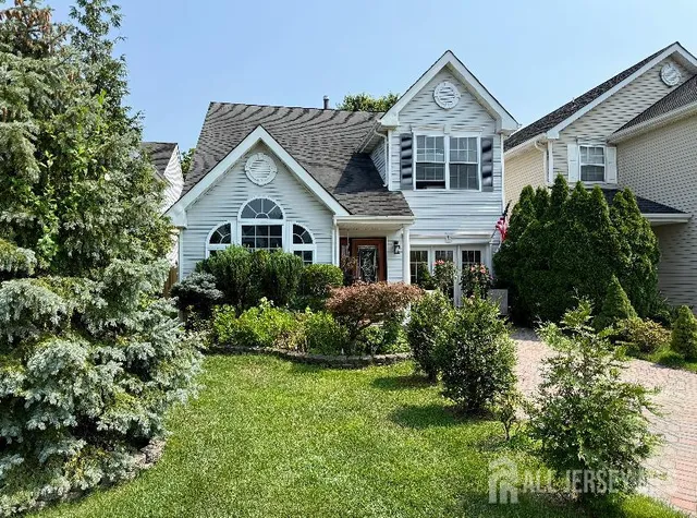 a front view of a house with a yard and potted plants