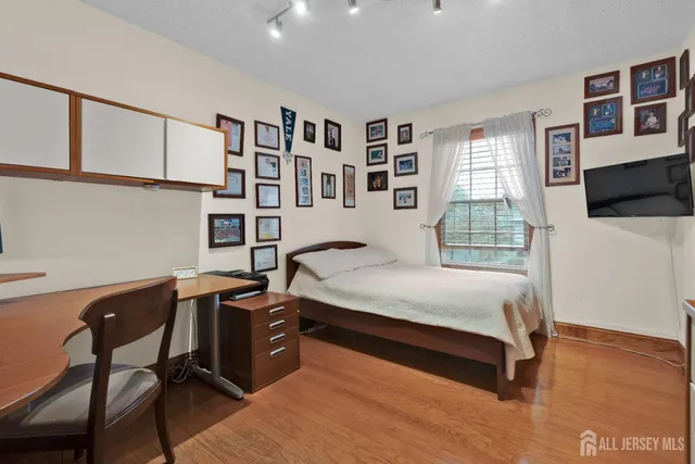 a bedroom with a bed a table and painting on the wall