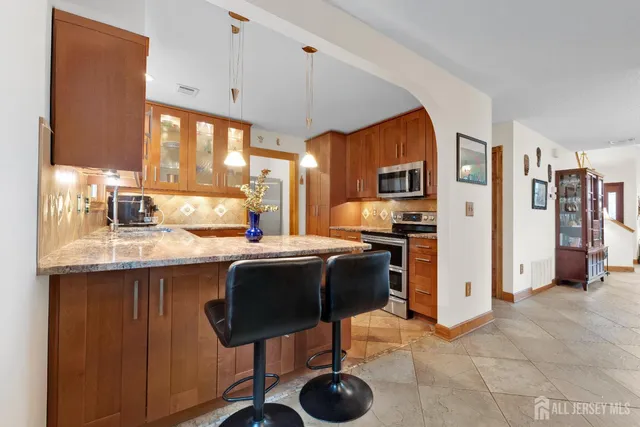 a kitchen with stainless steel appliances granite countertop a sink and a refrigerator