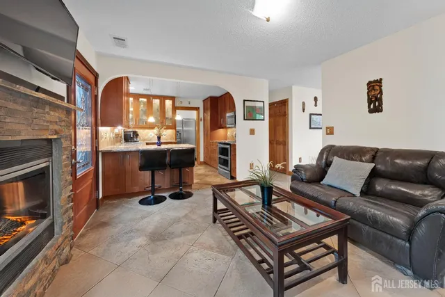 a living room with furniture a fireplace and a large window