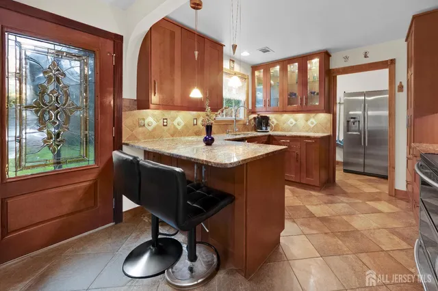 a kitchen with stainless steel appliances granite countertop a sink a stove a refrigerator and cabinets